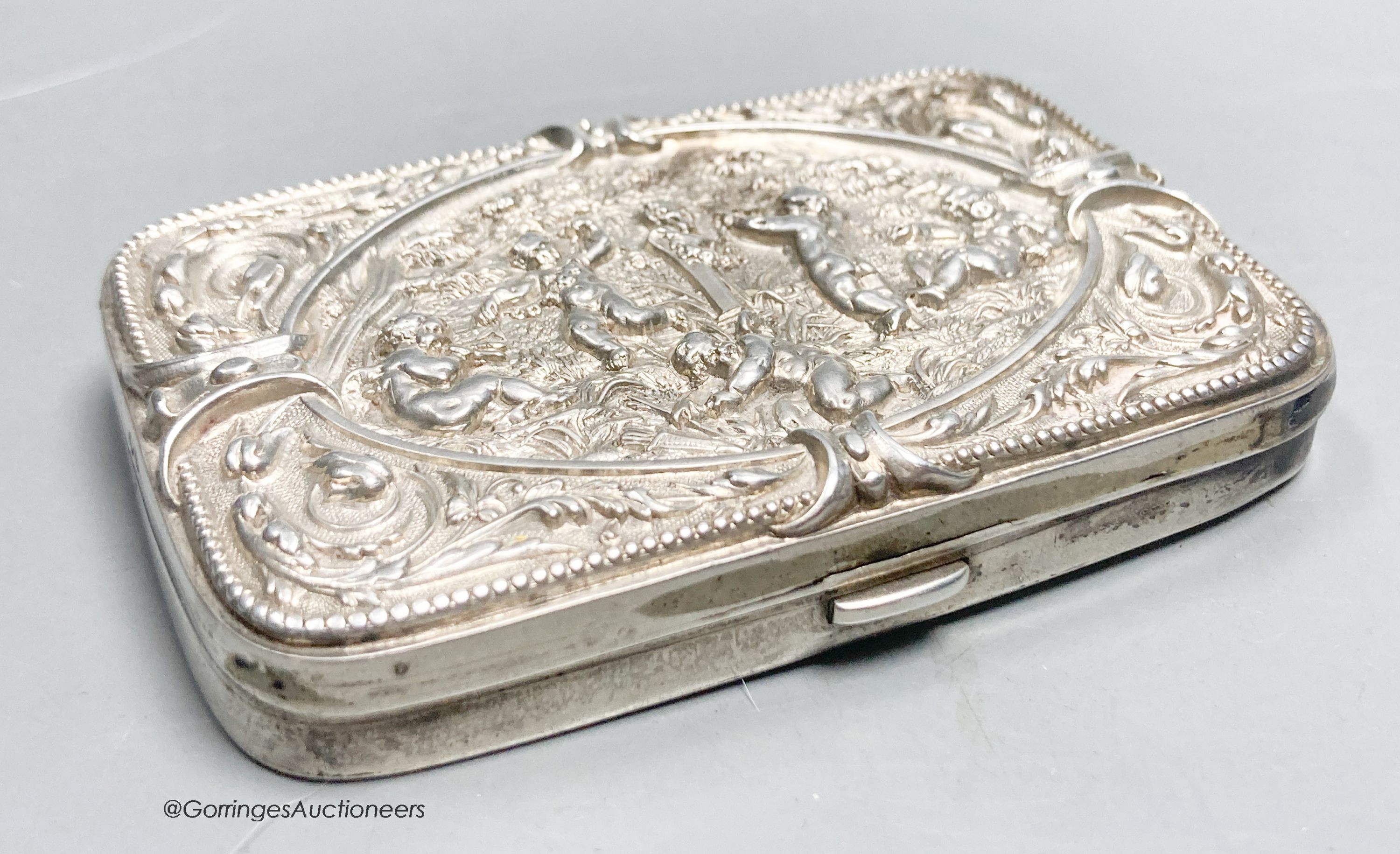 A late Victorian embossed silver shaped rectangular cigarette case, with mirrored interior, Birmingham, 1889, 81mm.